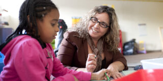 Teacher and girl coloring